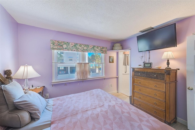 bedroom with a textured ceiling and light colored carpet