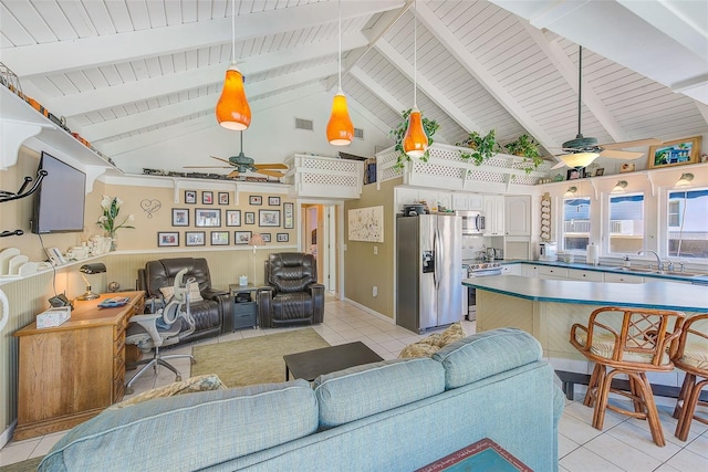 tiled living room with ceiling fan, lofted ceiling with beams, and sink