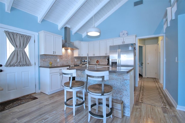 kitchen featuring white cabinetry, wall chimney range hood, and light wood-type flooring