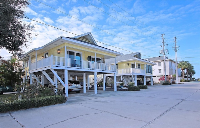 coastal inspired home featuring a porch and a carport