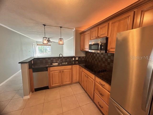 kitchen featuring backsplash, light tile patterned floors, sink, and appliances with stainless steel finishes