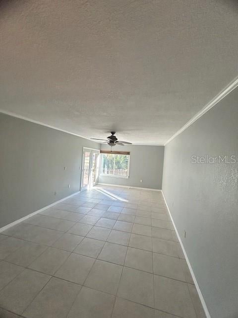 spare room with a textured ceiling, ceiling fan, crown molding, and light tile patterned flooring