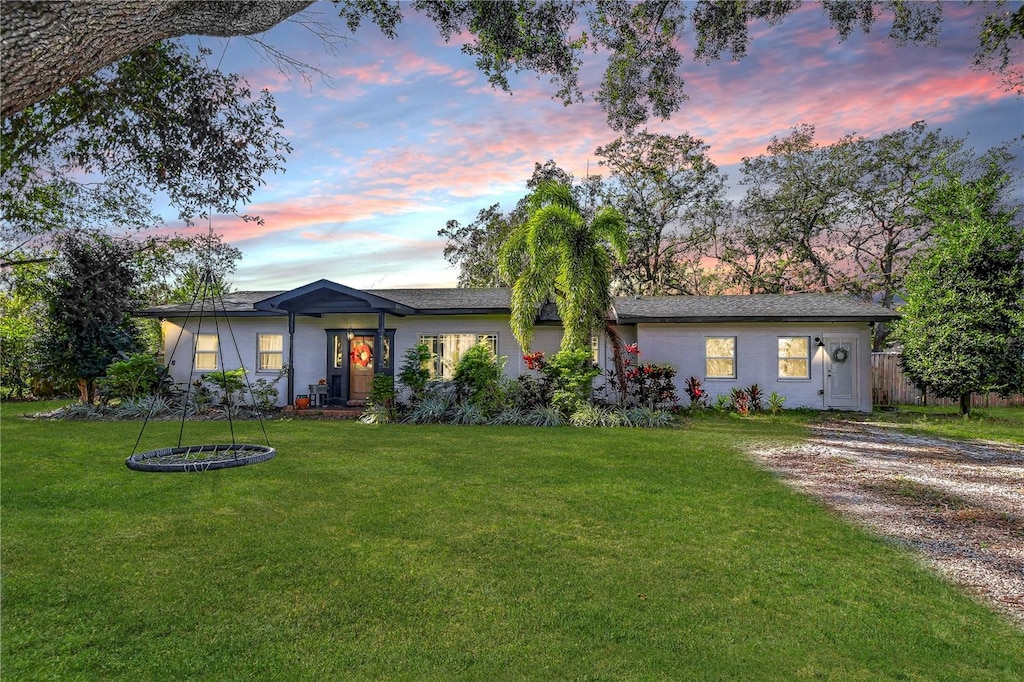 ranch-style home with a yard