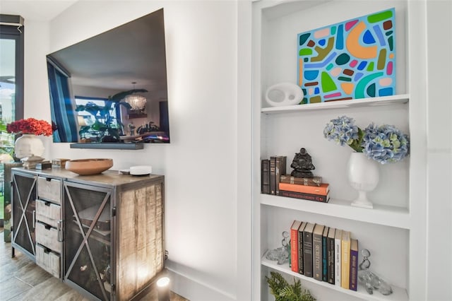 bar featuring hardwood / wood-style flooring and built in shelves