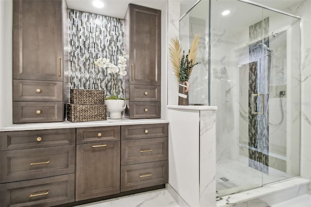 bathroom featuring a shower with door and vanity