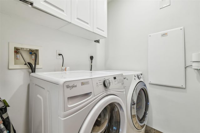 washroom with cabinets and washer and dryer