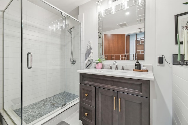 bathroom featuring vanity and a shower with door