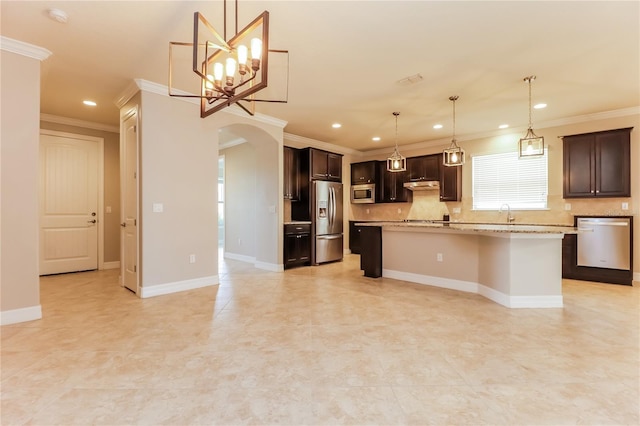 kitchen featuring a center island, hanging light fixtures, appliances with stainless steel finishes, tasteful backsplash, and dark brown cabinets