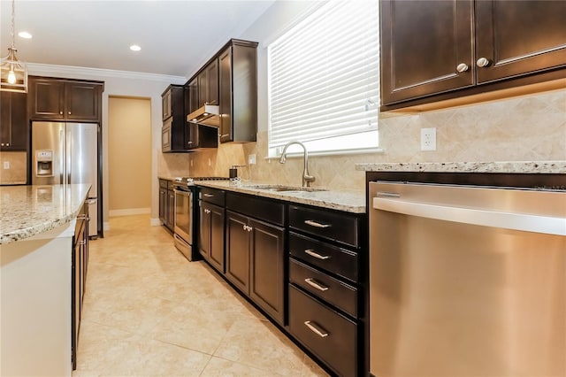 kitchen featuring light stone countertops, stainless steel appliances, crown molding, sink, and pendant lighting