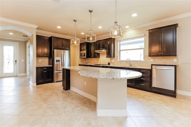 kitchen featuring stainless steel appliances, crown molding, sink, pendant lighting, and a kitchen island