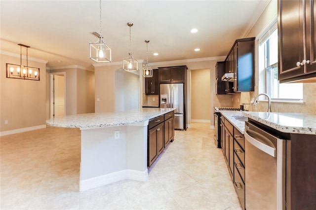 kitchen featuring pendant lighting, sink, light stone countertops, a kitchen island, and stainless steel appliances