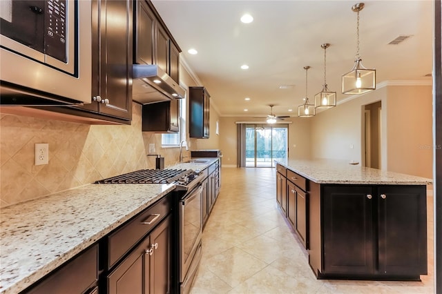 kitchen featuring high end range, ornamental molding, sink, exhaust hood, and hanging light fixtures