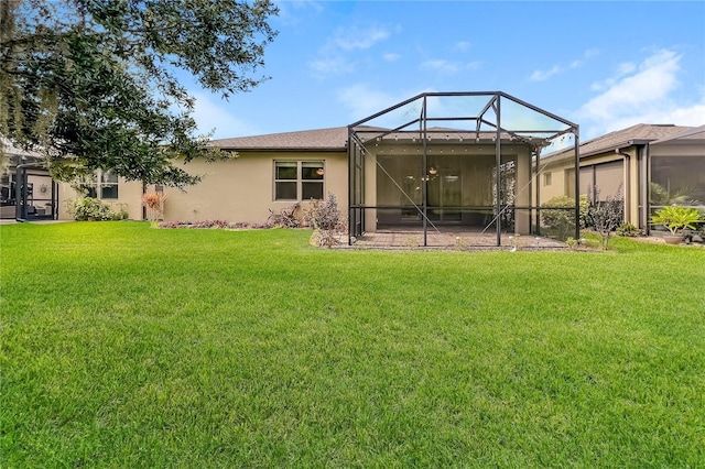 rear view of house with a lanai and a yard