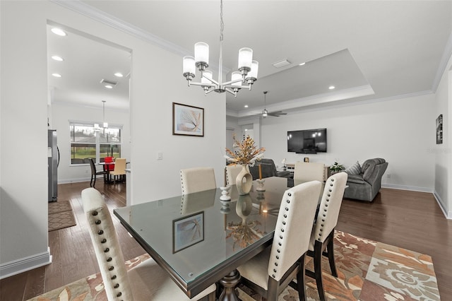 dining room featuring ceiling fan with notable chandelier, dark hardwood / wood-style flooring, and ornamental molding