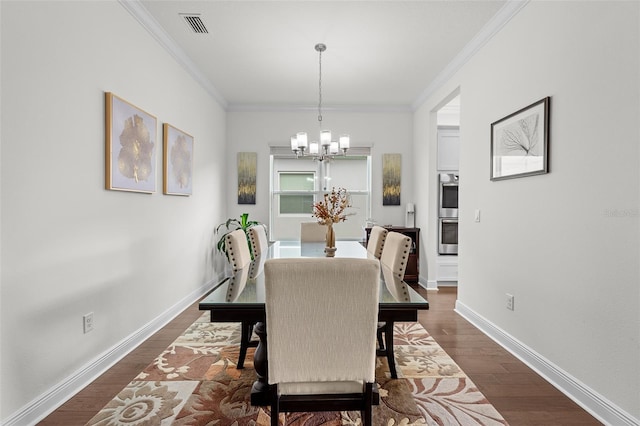 dining room with a notable chandelier, dark hardwood / wood-style flooring, and ornamental molding