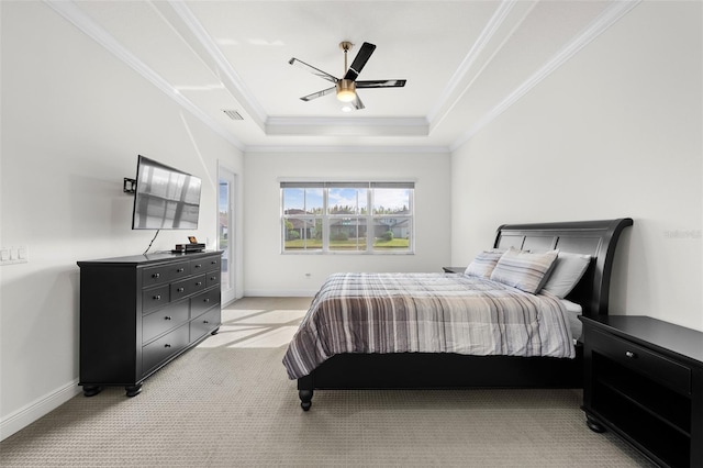 bedroom featuring ceiling fan, ornamental molding, light carpet, and a tray ceiling