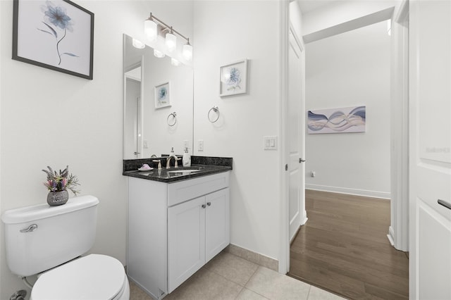 bathroom featuring wood-type flooring, vanity, and toilet