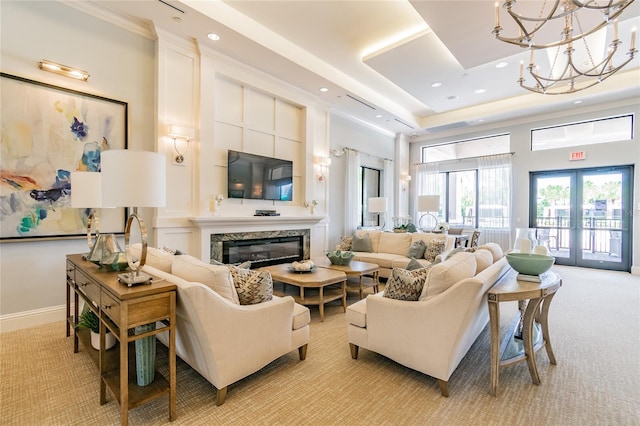 living room with a chandelier, a premium fireplace, french doors, and light colored carpet