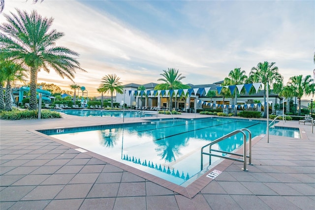 pool at dusk with a patio area