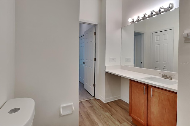 bathroom featuring toilet, vanity, and hardwood / wood-style flooring