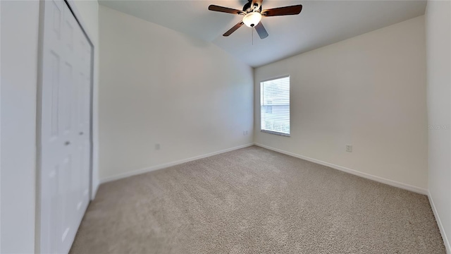 unfurnished bedroom with a closet, light colored carpet, vaulted ceiling, and ceiling fan