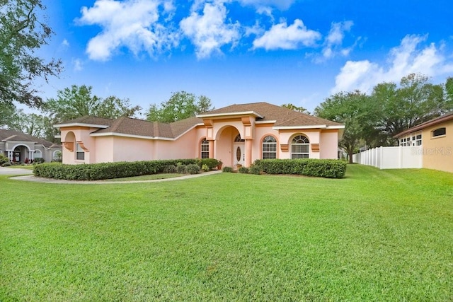 mediterranean / spanish home with a front lawn