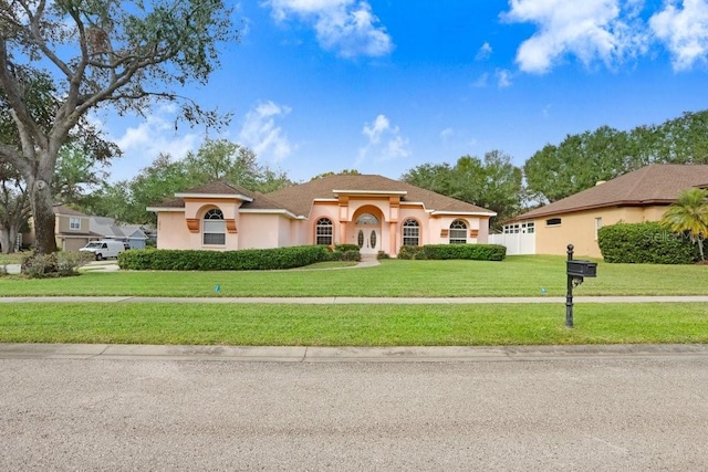 mediterranean / spanish-style home with a front lawn