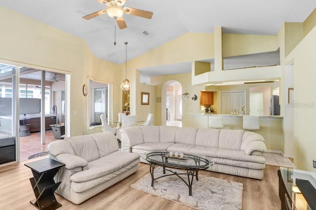 living room featuring ceiling fan, high vaulted ceiling, and light wood-type flooring