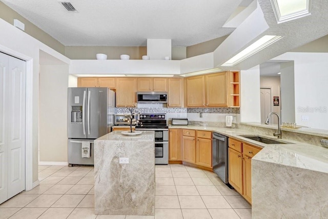 kitchen featuring sink, light tile patterned floors, tasteful backsplash, kitchen peninsula, and stainless steel appliances