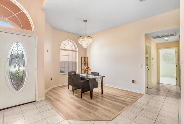 foyer entrance featuring light tile patterned flooring and a chandelier