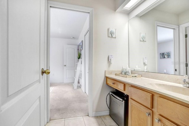 bathroom featuring tile patterned floors, a skylight, and vanity