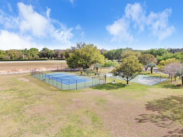 view of tennis court featuring a lawn