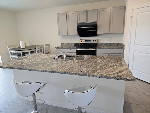 kitchen with gray cabinets, sink, light tile patterned floors, and stainless steel range with electric stovetop