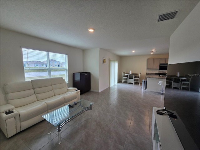 living room featuring light tile patterned flooring and a textured ceiling