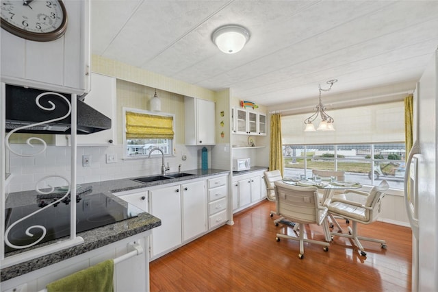 kitchen with white cabinets, light wood-type flooring, and a wealth of natural light