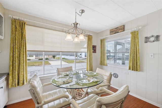 dining room with a notable chandelier, dark hardwood / wood-style flooring, and a wealth of natural light