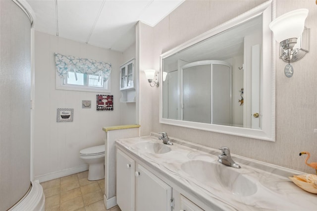 bathroom with tile patterned flooring, vanity, toilet, and an enclosed shower