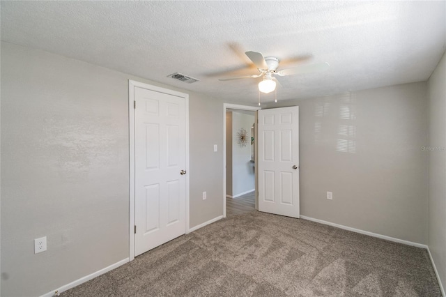 unfurnished bedroom featuring ceiling fan, carpet floors, and a textured ceiling