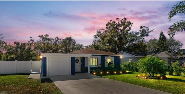 single story home featuring a garage and a lawn