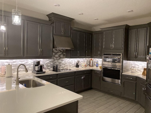 kitchen featuring backsplash, black electric cooktop, double oven, and sink