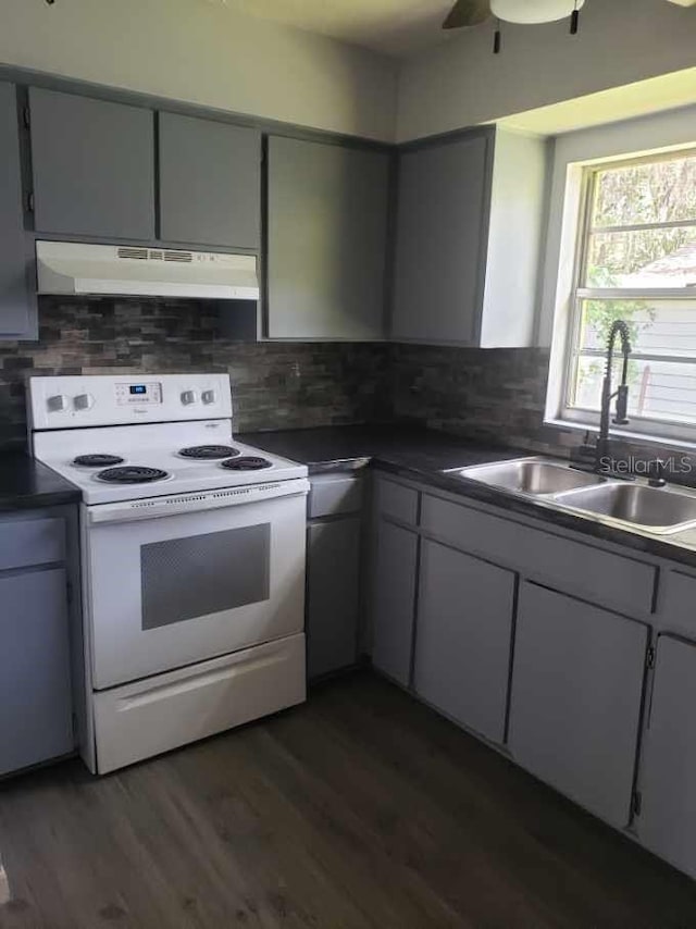 kitchen featuring decorative backsplash, dark hardwood / wood-style flooring, white range with electric stovetop, ceiling fan, and sink