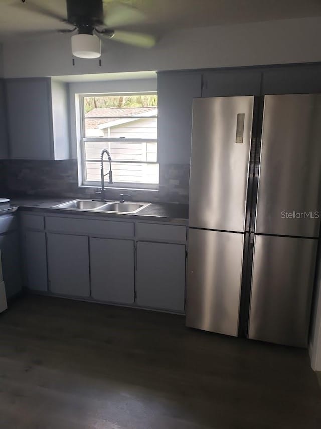 kitchen with stainless steel refrigerator, ceiling fan, sink, decorative backsplash, and white cabinets