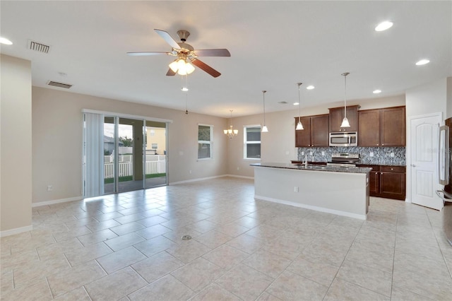 kitchen featuring a center island with sink, ceiling fan with notable chandelier, tasteful backsplash, decorative light fixtures, and stainless steel appliances