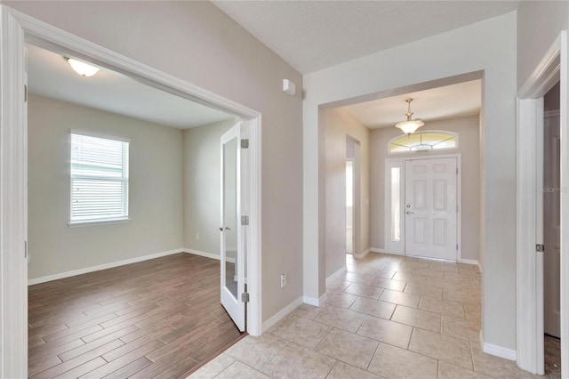 entryway with a textured ceiling and light hardwood / wood-style flooring