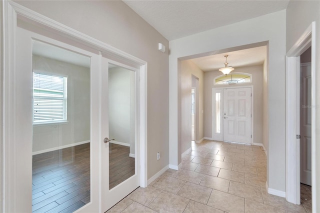 foyer with a textured ceiling and light hardwood / wood-style flooring