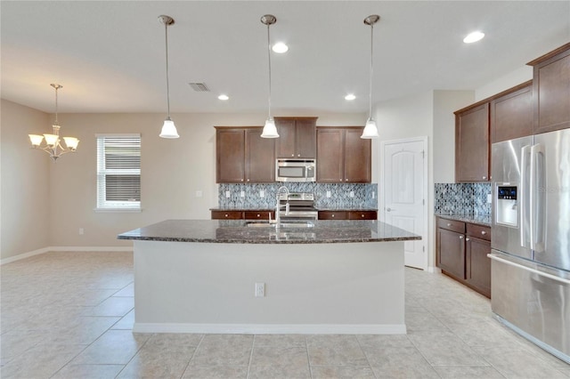 kitchen with stainless steel appliances, sink, pendant lighting, an island with sink, and light tile patterned flooring