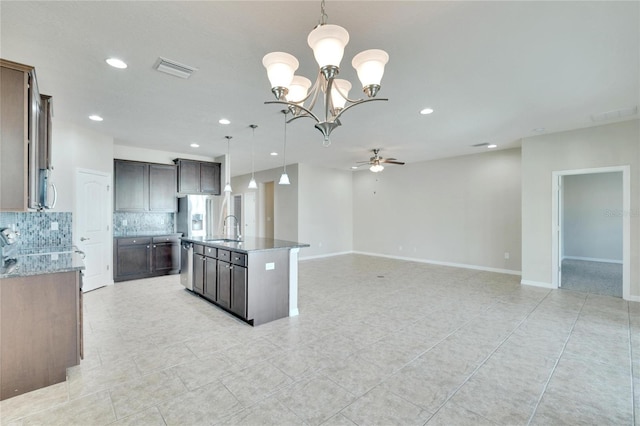 kitchen featuring ceiling fan with notable chandelier, decorative light fixtures, backsplash, and sink