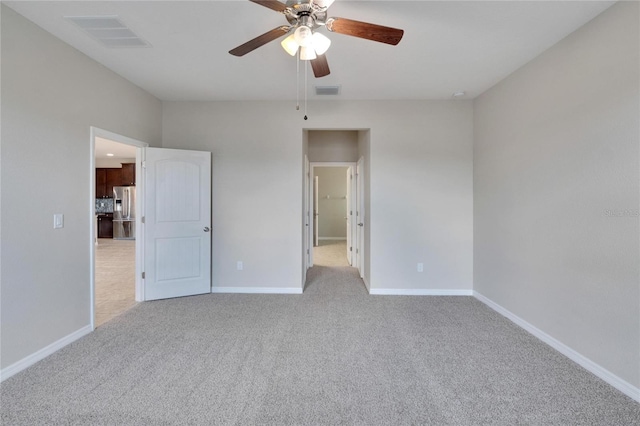 unfurnished bedroom featuring stainless steel fridge, light colored carpet, and ceiling fan