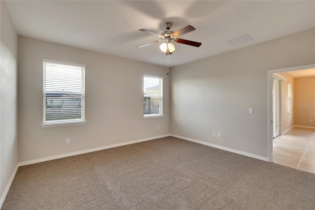 spare room featuring light carpet and ceiling fan