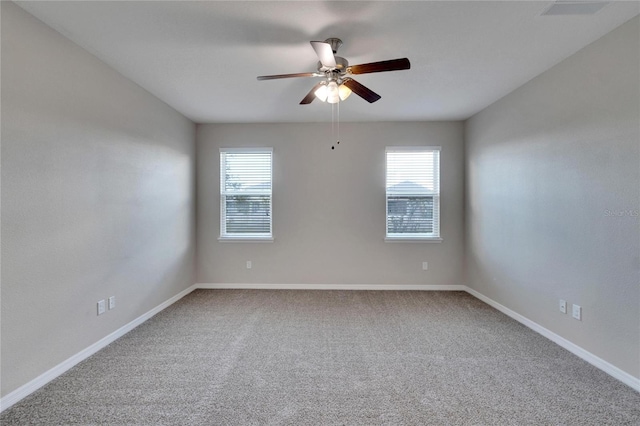 spare room with carpet flooring, ceiling fan, and a healthy amount of sunlight